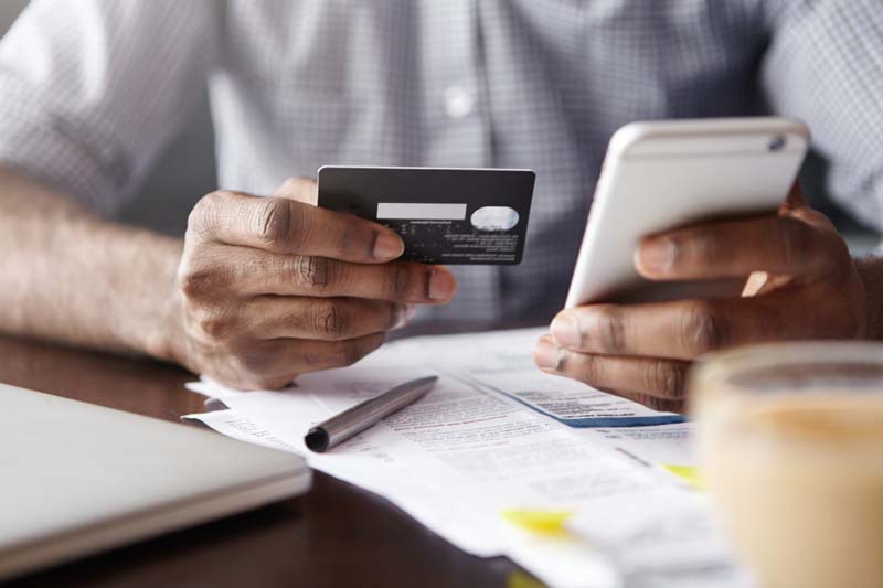 Close-up,View,Of,African,Man's,Hands,Holding,Plastic,Credit,Card